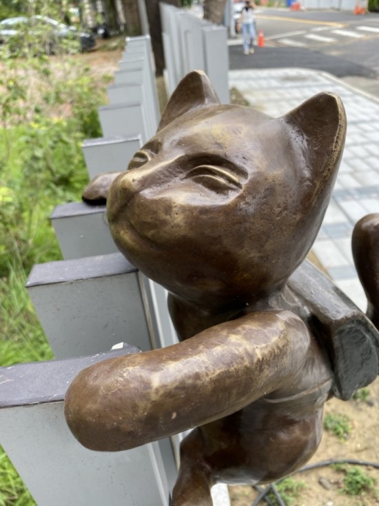 半夢(mèng)半醒的貓咪攀牆上學(xué)，摹寫著孩童們匆忙上學(xué)的日常，藝術(shù)家─曾永玲發(fā)揮天馬行空的想像投設(shè)其中。