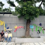 築起一座座小小的山丘，承載著各類小動物們，將一面泥灰的牆面賦予繽紛的生命力，並傳達『生命關懷、愛物惜物』的感恩之心給所有孩子們。(圖中間為藝術家張婷雅)