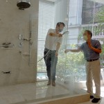 新業(yè)建設(shè)卓勝隆董事長（右）伸手測試三段式水流變化為肌膚帶來的觸感，親身體驗(yàn)，精選出舒心的衛(wèi)浴設(shè)備。