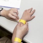 活動開始之前，工作人員協(xié)助大、小朋友們戴上分組的幸運(yùn)手環(huán)。