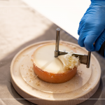 半硬質(zhì)家族的修道士(TETE DE MOINE)，呈小型鼓狀，外殼有點(diǎn)油膩、呈褐色，乳酪團(tuán)結(jié)實(shí)且濃郁，隨著熟成顏色會(huì)加深，以轉(zhuǎn)臺(tái)式乳酪削切器，削成花摺邊小花苞。