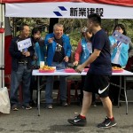 現(xiàn)場新業(yè)建設(shè)穆椿松名譽董事長（左二）與卓勝隆董事長（左一）引領(lǐng)大家，加油吶喊給予跑者支持。