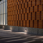 社區(qū)一隅採用「紅磚清水磚」錯(cuò)落排列，夜晚透過隱藏式照明，營造出層次豐富的光影效果，為空間注入溫潤而靜謐的氣氛。