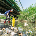 躺在水面上的鐵鋁罐、玻璃瓶，是每逢大雨後，上游沖刷下來的人為垃圾，彎下腰、踏進溪流，撿起水中的垃圾殘骸，還給魚兒一個安全舒適的家園。