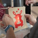 剛完成的剪紙，辛卯喜兔浮躍紙上，手捧著元寶寓意財源滾滾，家族發(fā)揮創(chuàng)意增添
兩顆小愛心，俏皮且生動的趣味十足。