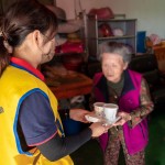 「阿嬤呷飯囉!」，甘霖基金會志工將便當(dāng)送到獨(dú)居長輩手中的同時，也不忘送上一兩句暖心的問候。