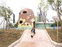 新業(yè)建設董事長卓勝隆童心大發(fā)，在碉堡地景溜滑梯。