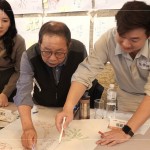 新業(yè)建設(shè)卓勝隆董事長(圖中)與工地主任，共同探討樹木容易死亡的原因，及分析各面向可能的解決方案。