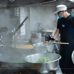 早上六點(diǎn)開(kāi)始，中央廚房與志工著手備餐，馬不停蹄的來(lái)回穿梭，從打菜到分裝都與時(shí)間賽跑著，每個(gè)流程都是滿滿的真心與付出。